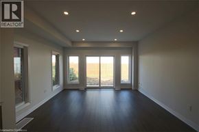 Hamilton townhouse for rent - A spacious room with a sliding glass door leading to a backyard.