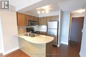 Toronto (Bay Street Corridor) condo for rent - A kitchen with a refrigerator, microwave, and stove.