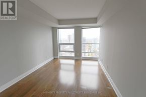 Toronto (Bay Street Corridor) condo for rent - A room with wooden floors and white walls, with a window and a door leading to a balcony.