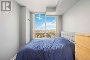 Mississauga (Rathwood) condo for rent - A bedroom with a bed, a window, and a view of the city.