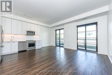 Toronto (Kingsway South) condo for rent - A spacious kitchen with white cabinets and a microwave above the stove.