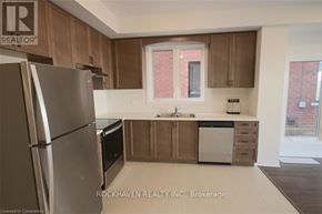 Hamilton (Gibson) townhouse for rent - A kitchen with a refrigerator, sink, and cabinets.
