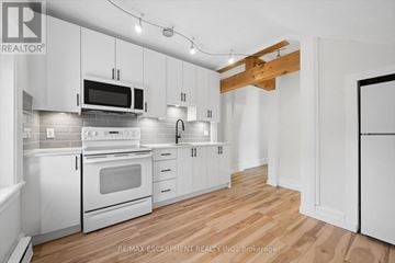 Cambridge multi-family for rent - A kitchen with white cabinets and a wooden beam on the ceiling.