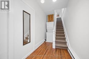 Cambridge multi-family for rent - A hallway with a staircase and a mirror on the wall.