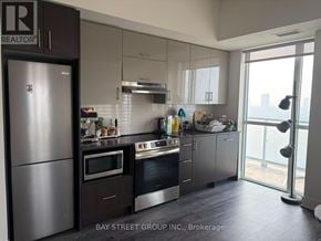 Toronto (Don Valley Village) condo for rent - A modern kitchen with a refrigerator and stove top oven.