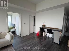 Toronto (Don Valley Village) condo for rent - A living room with a couch, a chair, and a dining table.