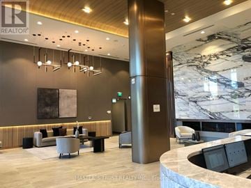 Toronto (York University Heights) condo for rent - A reception area with a marble wall and a large column.