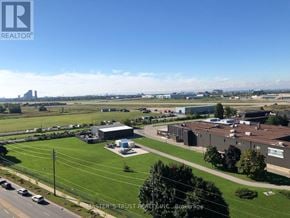 Toronto (York University Heights) condo for rent - A real estate company's brokerage office is located in a large, open area with a parking lot and several buildings.