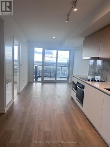 Toronto (York University Heights) condo for rent - A kitchen with white cabinets and a wooden floor.