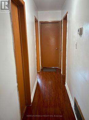 Mississauga (Malton) apartment for rent - A hallway with wooden floors and white walls.