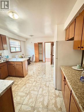 Mississauga (Malton) apartment for rent - A kitchen with wooden cabinets and a tiled floor.
