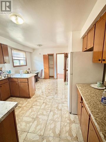 Mississauga (Malton) apartment for rent - A kitchen with wooden cabinets and a tiled floor.