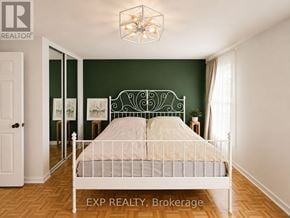Toronto (Etobicoke West Mall) townhouse for rent - A bedroom with a white bed and a chandelier.