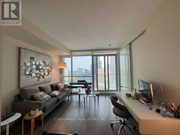 Toronto (Bay Street Corridor) condo for rent - A living room with a grey couch and a painting on the wall.