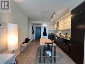 Toronto (Bay Street Corridor) condo for rent - A modern kitchen with dark brown cabinets and a wooden table.