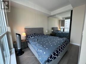 Toronto (Bay Street Corridor) condo for rent - A bedroom with a bed, nightstand, and lamp.