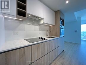 Toronto (Moss Park) condo for rent - A modern kitchen with wooden cabinets and a marble countertop.