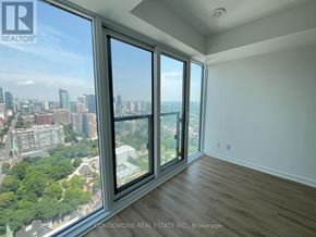 Toronto (Moss Park) condo for rent - A room with a large window overlooking a cityscape.