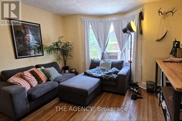 Toronto (Wychwood) apartment for rent - A living room with a grey couch and a black ottoman.