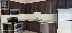 Kitchener townhouse for rent - A kitchen with brown cabinets and a white refrigerator.