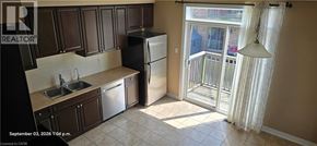 Kitchener townhouse for rent - A kitchen with a sink, refrigerator and a window.