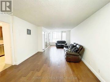 Toronto (Bay Street Corridor) condo for rent - A living room with a brown leather couch and a black ottoman.