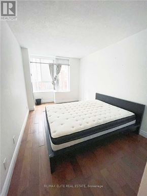 Toronto (Bay Street Corridor) condo for rent - A bedroom with a large bed and wooden floors.
