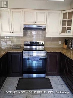 Markham (Cornell) townhouse for rent - A kitchen with a stove top oven and cabinets.