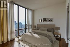 Toronto (Church-Yonge Corridor) condo for rent - A bedroom with a large bed and a view of the city.