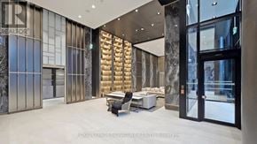 Toronto (Kensington-Chinatown) condo for rent - A spacious lobby with a glass wall and a wooden partition.