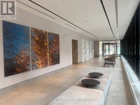 Toronto (North St. James Town) condo for rent - A hallway with a large painting on the wall and a bench in the middle.
