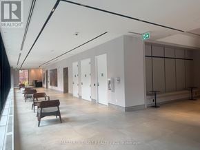 Toronto (North St. James Town) condo for rent - A hallway with chairs and a sign that says Brokerage.