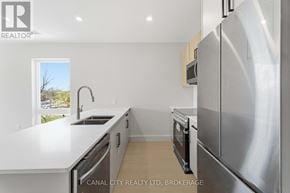 Thorold (Thorold Downtown) apartment for rent - A modern kitchen with stainless steel appliances and a view of the outdoors through a window.