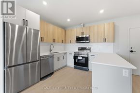 Thorold (Thorold Downtown) apartment for rent - A modern kitchen with stainless steel appliances and wooden cabinets.