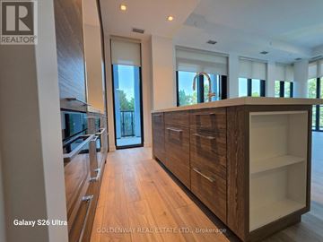 Toronto (Bayview Village) condo for rent - A modern kitchen with wooden cabinets and a large island.