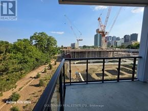 Toronto (Bayview Village) condo for rent - A construction site is visible from a balcony with a view of a city skyline in the distance.