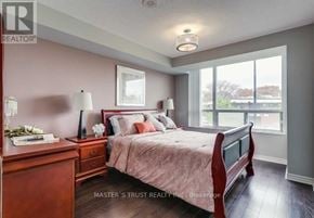 Toronto (Woburn) condo for rent - A bedroom with a bed, nightstand, and a window overlooking a view.