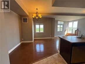 Sudbury apartment for rent - A well-lit kitchen and living room with a chandelier and a window.