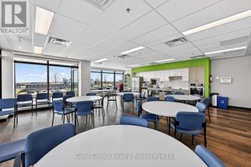 Woodstock (Woodstock - South) apartment for rent - A conference room with a table and chairs in the foreground and a kitchen area in the background.