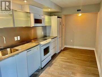 Toronto (Waterfront Communities) condo for rent - A kitchen with white appliances and wooden floors.