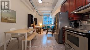 Toronto (Church-Yonge Corridor) condo for rent - A modern kitchen with stainless steel appliances and wooden cabinets.