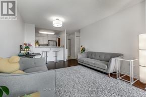 Toronto (Newtonbrook East) condo for rent - A living room with a grey couch and a white chair.