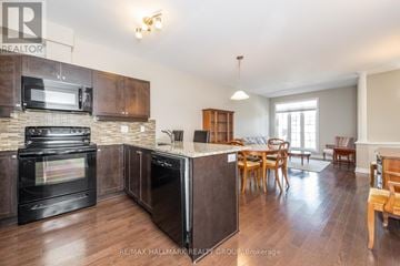 Ottawa townhouse for rent - A kitchen with dark wood cabinets and a black oven.