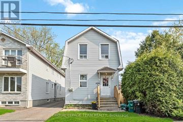 Ottawa apartment for rent - A house with a white facade is for sale, as indicated by the sign on the front.