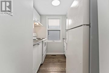 Ottawa apartment for rent - A white refrigerator is in a kitchen with white cabinets.