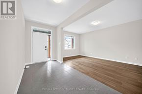 Ottawa apartment for rent - A spacious room with wooden flooring and a sliding glass door leading to a balcony.