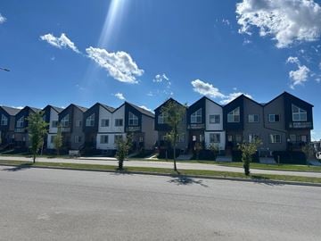 Calgary apartment for rent - A row of modern townhouses with trees in front.