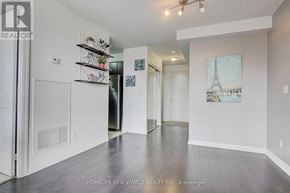 Toronto (Henry Farm) condo for rent - A spacious room with a white door and a fridge, with a wall art of Eiffel tower.