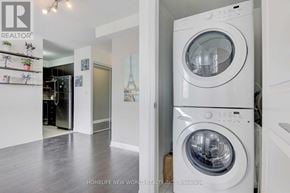Toronto (Henry Farm) condo for rent - A white washing machine is in a laundry room with a view of the Eiffel Tower.