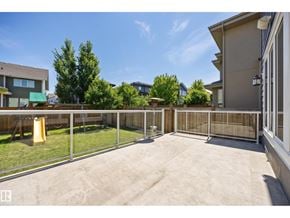 Edmonton apartment for rent - A backyard with a fence and a yellow trash can.